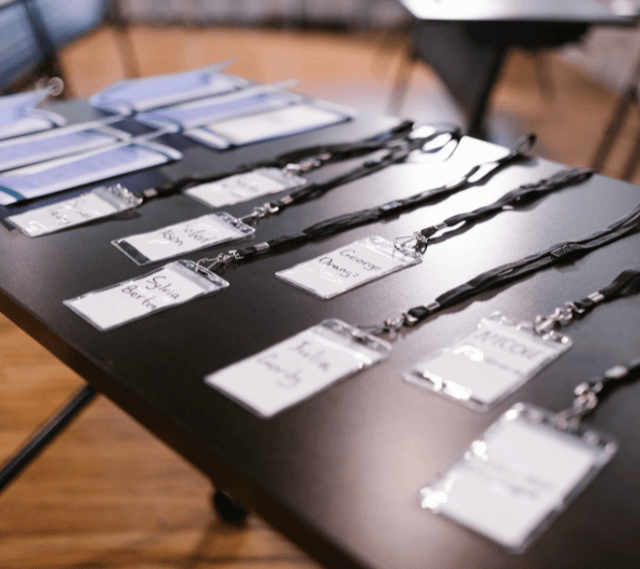 photo of a table at a conference with name badges laid out
