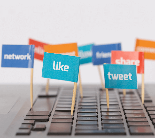 keyboard with small flags coming out of it showcasing likes, tweets, shares, and networking